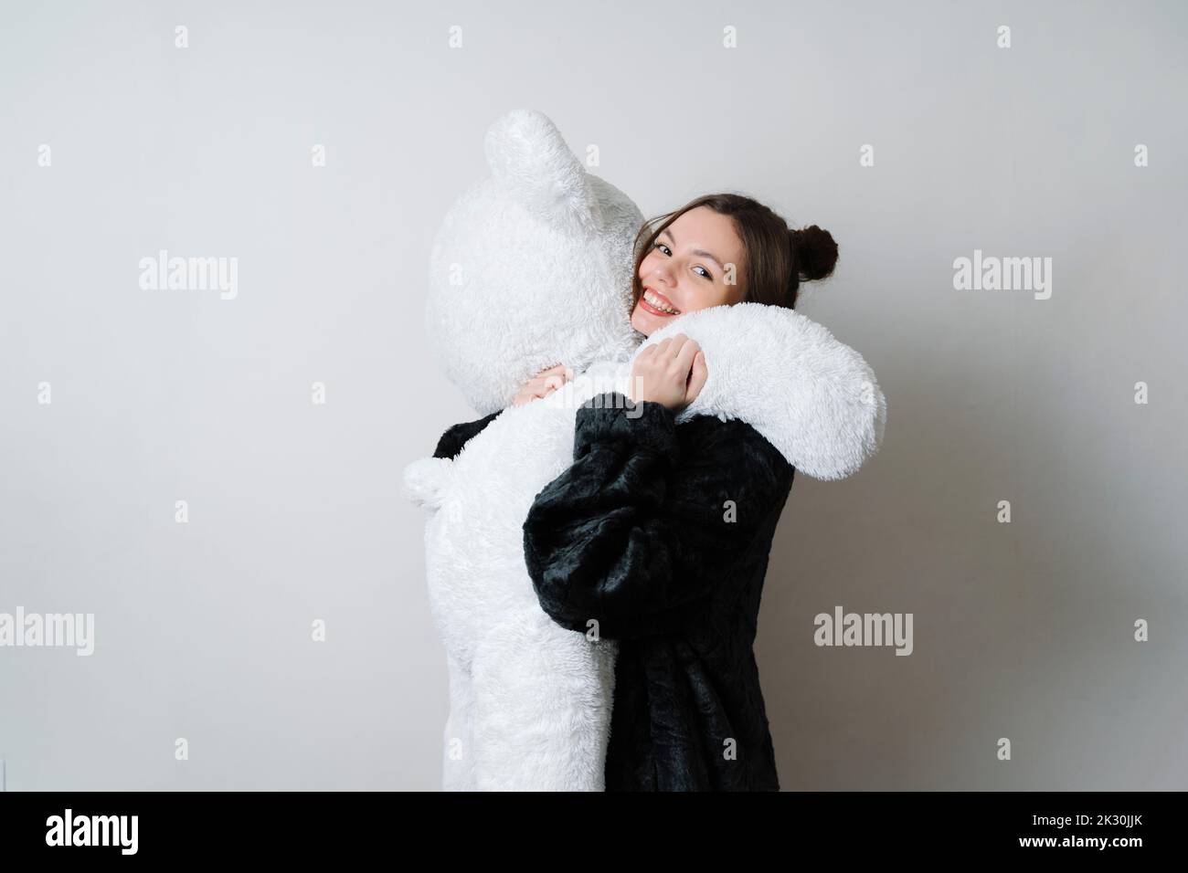 Femme souriante tenant un ours en peluche Banque D'Images