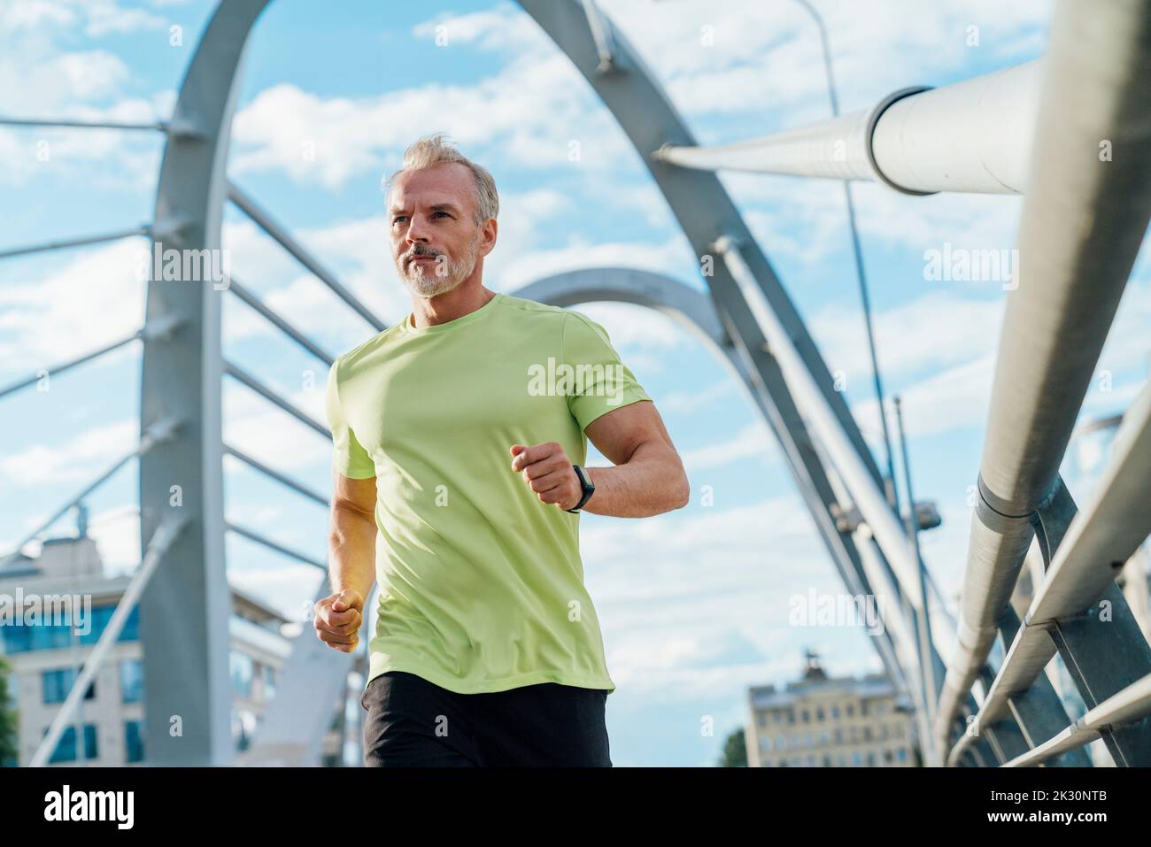 Homme en train de courir sur le pont suspendu en ville Banque D'Images