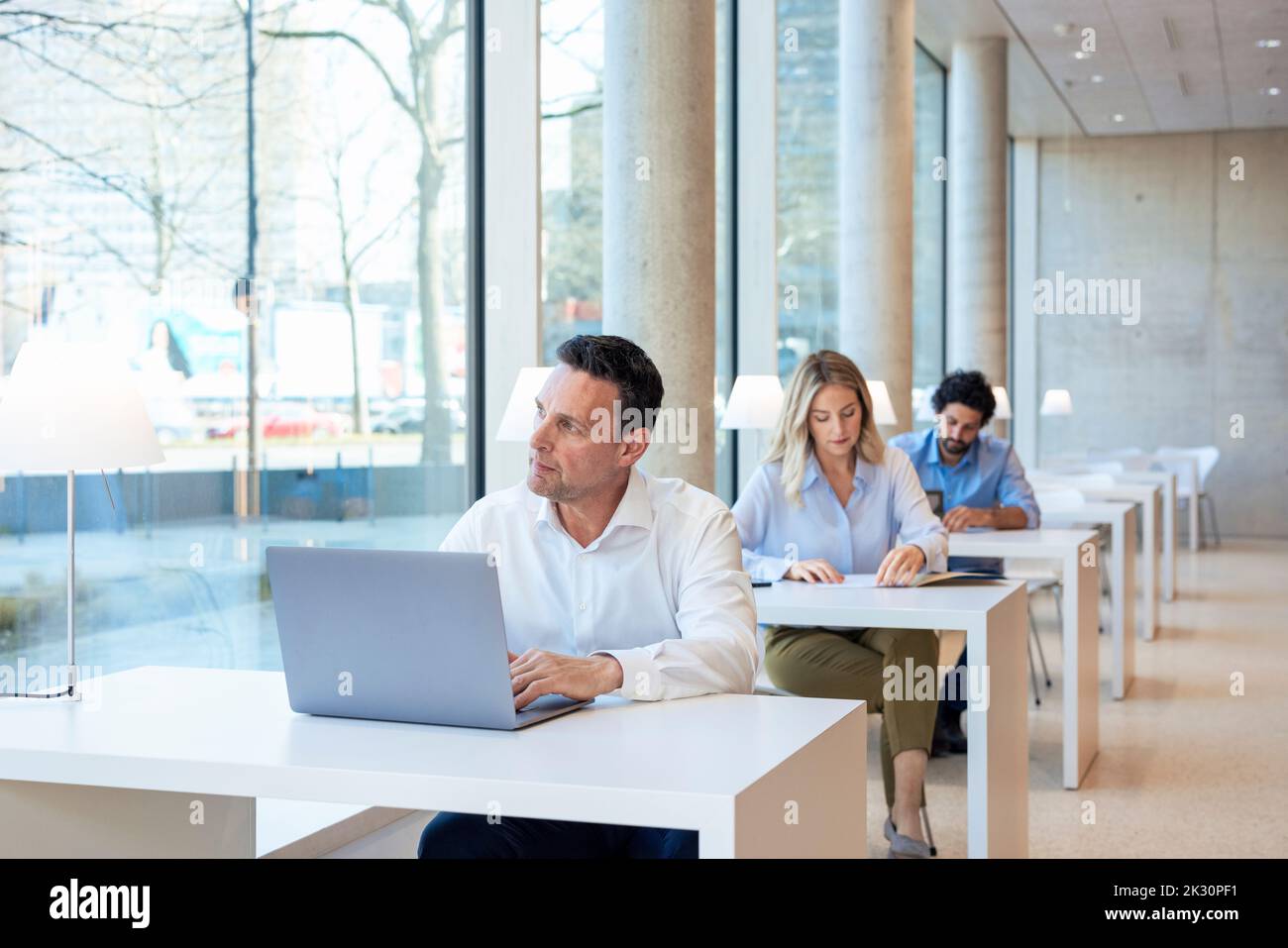 Professeur d'université avec ordinateur portable sur le bureau Banque D'Images