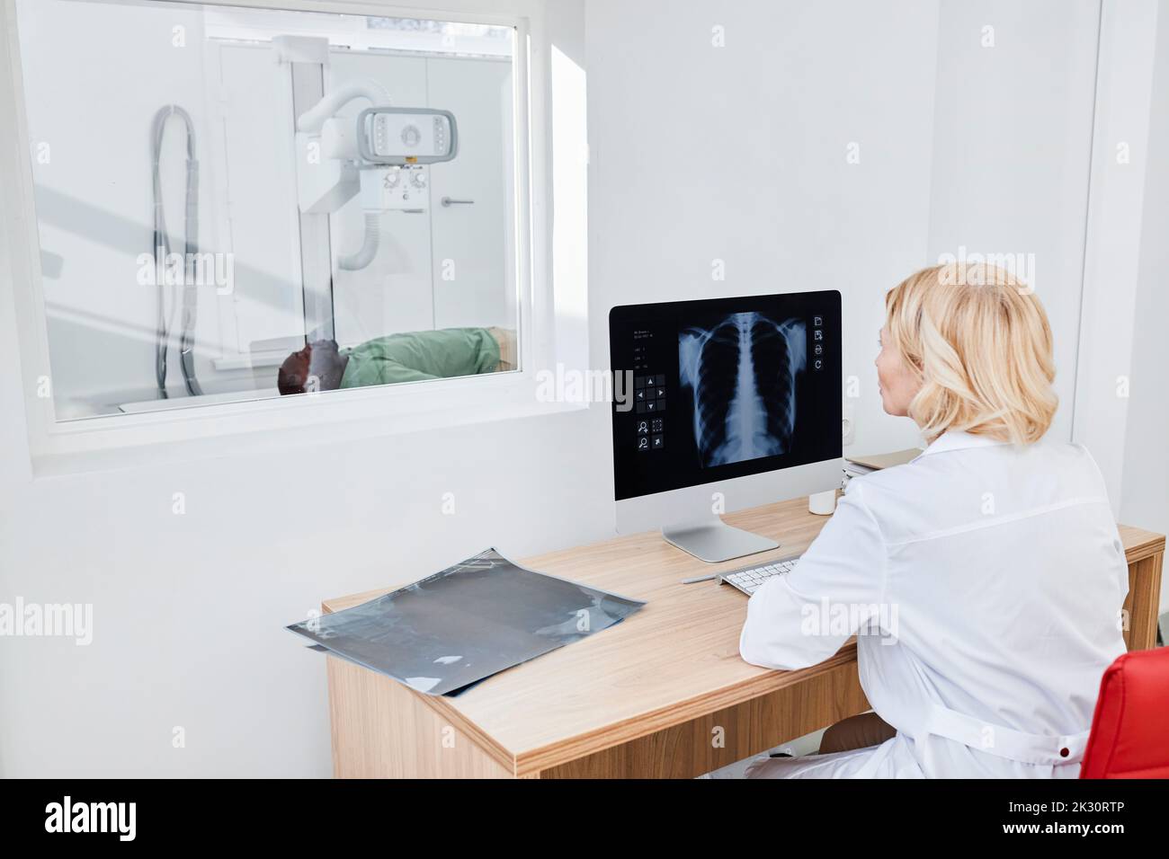 Radiologue prenant une radiographie du patient en clinique Banque D'Images