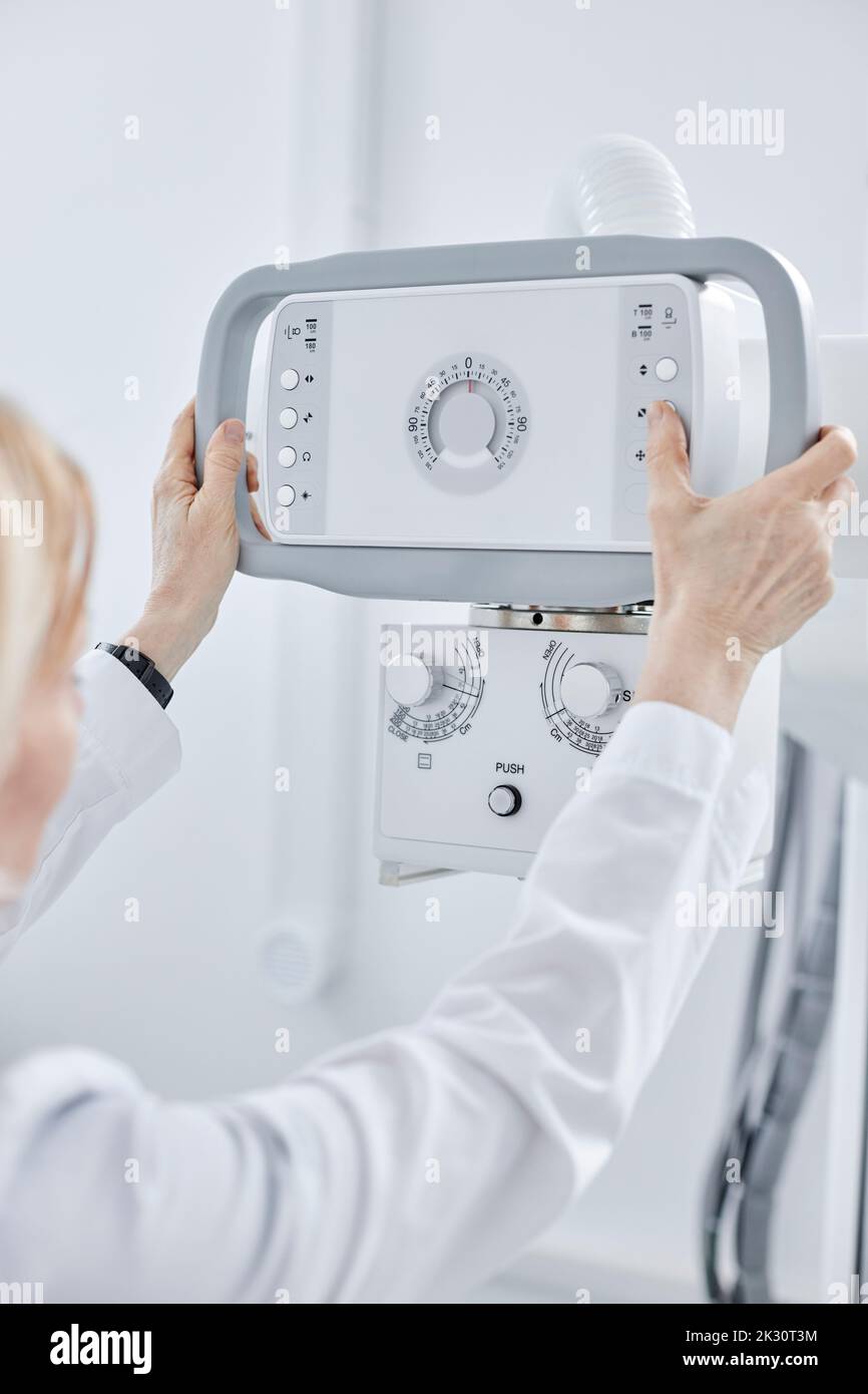 Médecin contrôlant la machine à rayons X en clinique Banque D'Images