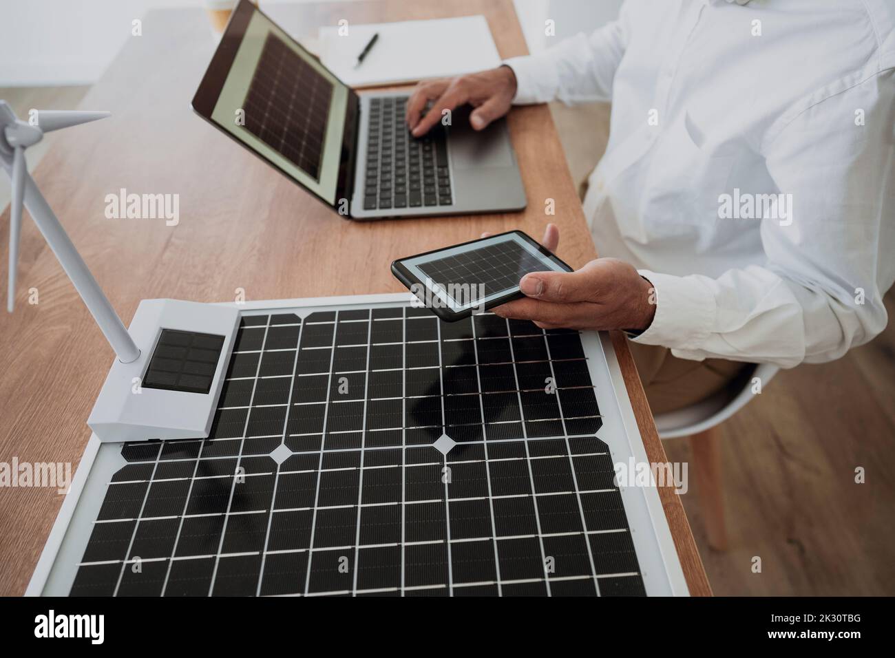 Ingénieur utilisant l'ordinateur portable assis avec la technologie verte au bureau Banque D'Images