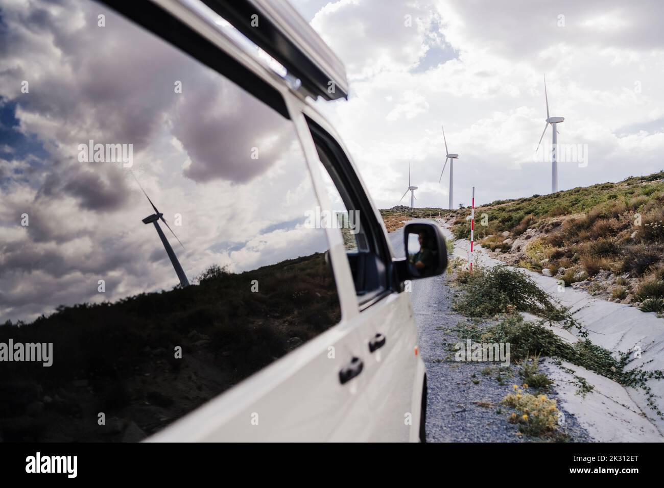 Fourgonnette sur le bord de la route avec réflexion de l'éolienne sur la vitre Banque D'Images