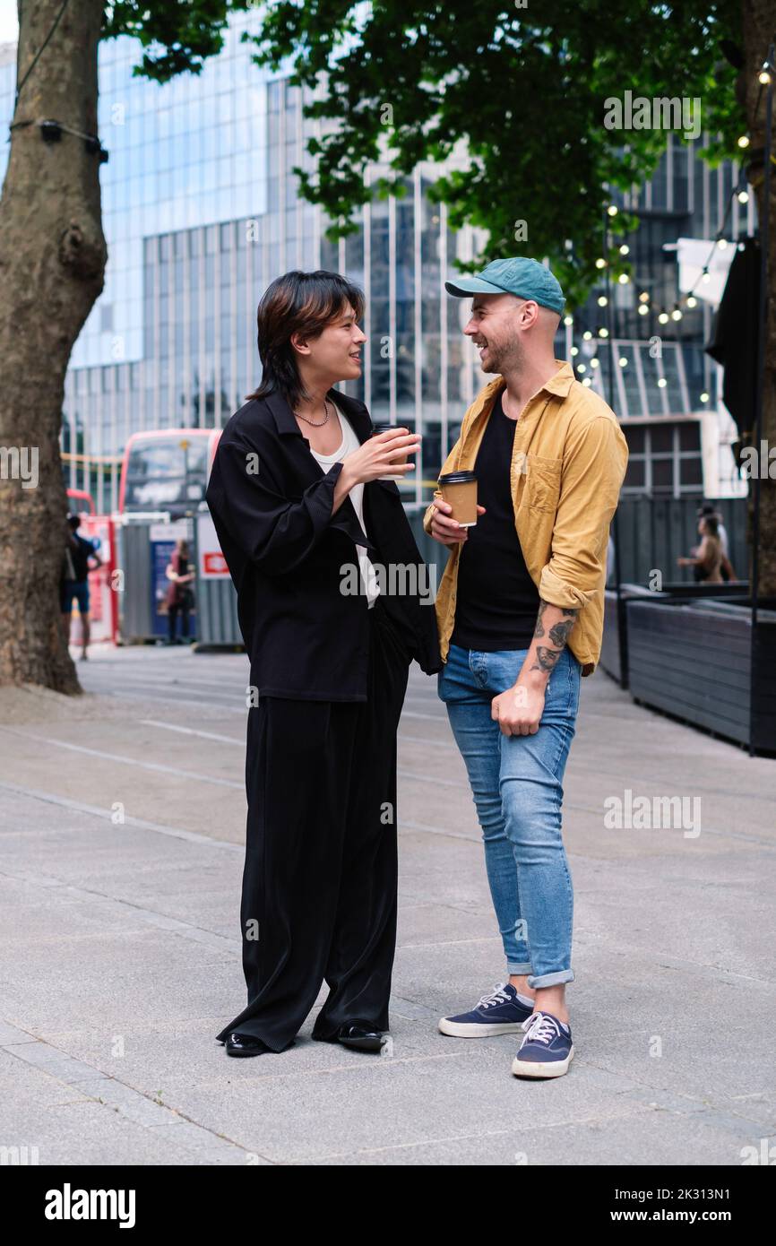Jeune homme parlant avec un petit ami debout sur une piste de marche Banque D'Images