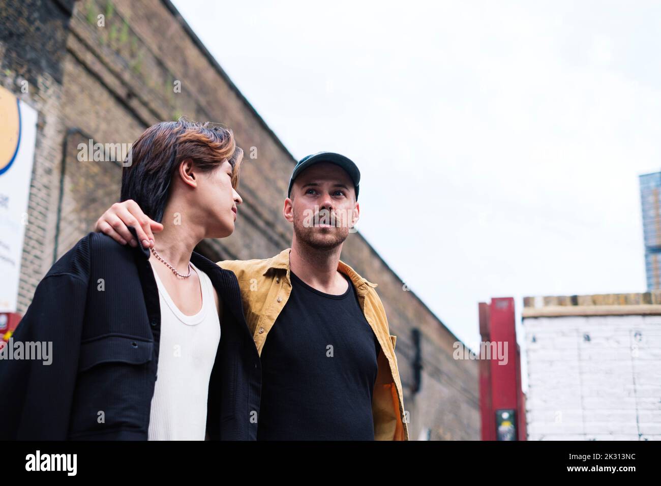 Jeune homme regardant le petit ami devant le bâtiment Banque D'Images