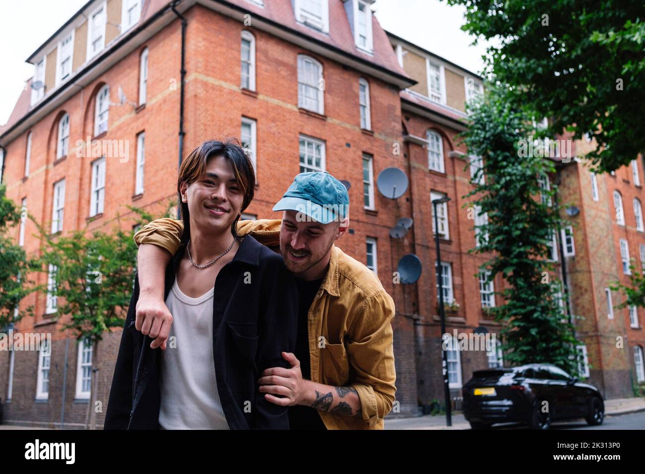 Un homme gay heureux avec le bras autour de jeune petit ami dans la ville Banque D'Images