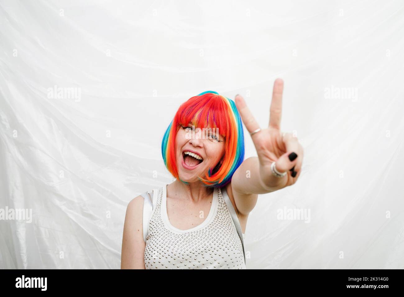 Bonne femme dans les cheveux colorés teints montrant le signe de la paix geste Banque D'Images
