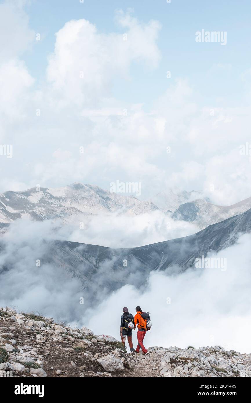 Randonneurs marchant ensemble sur le bord de la montagne Banque D'Images
