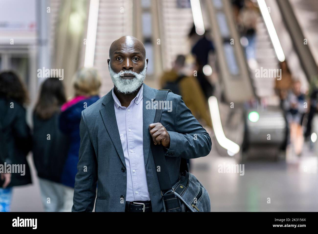 Homme d'affaires sérieux avec sac d'ordinateur portable à la gare Banque D'Images