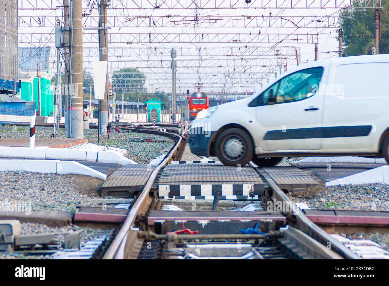 Kemerovo, Russie - 01 septembre 2022. Une voiture de tourisme commerciale pour livraison à temps traverse le passage à niveau en face du train, sélective FO Banque D'Images