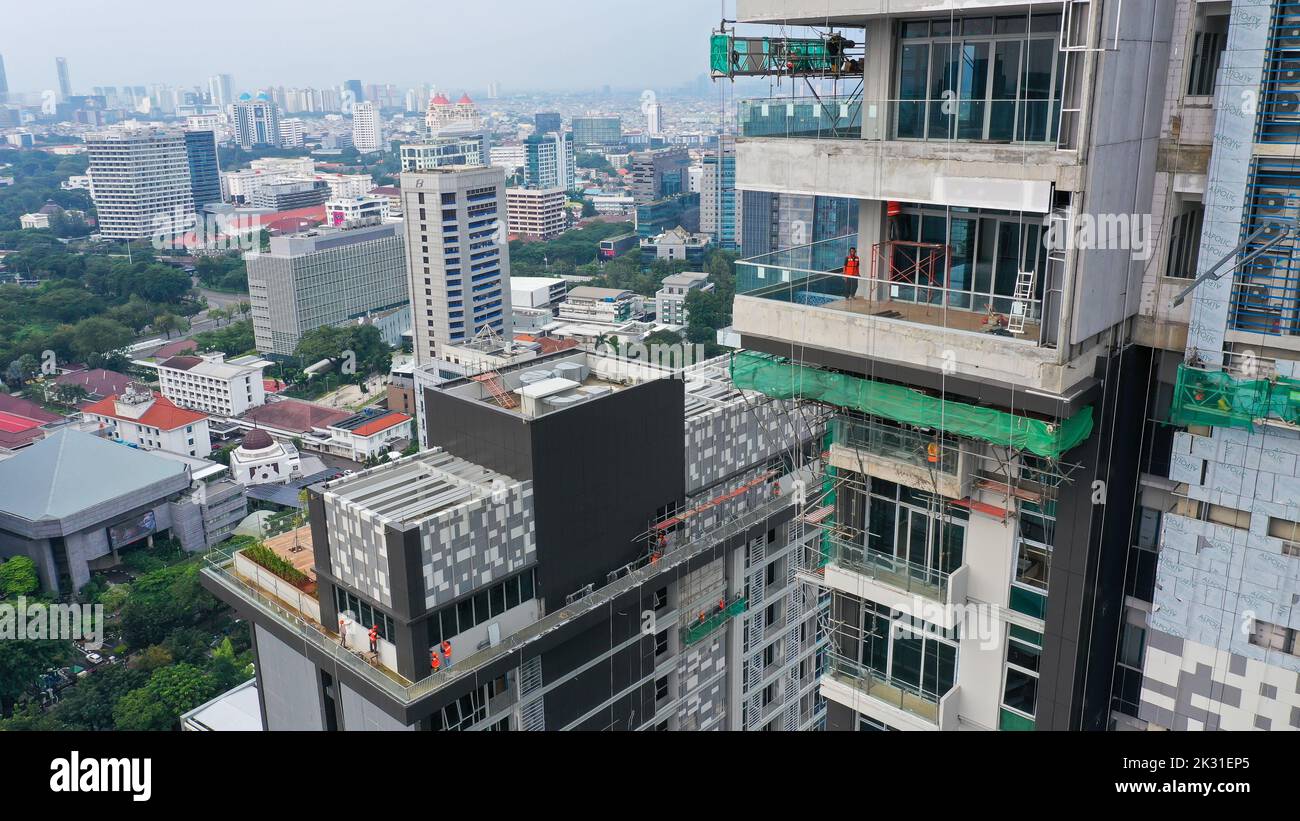 Java, Jakarta, Indonésie, 20 mai 2022. Les travailleurs utilisent la gondole comme support de transport vertical pour installer du composite d'aluminium sur le bâtiment de construction Banque D'Images