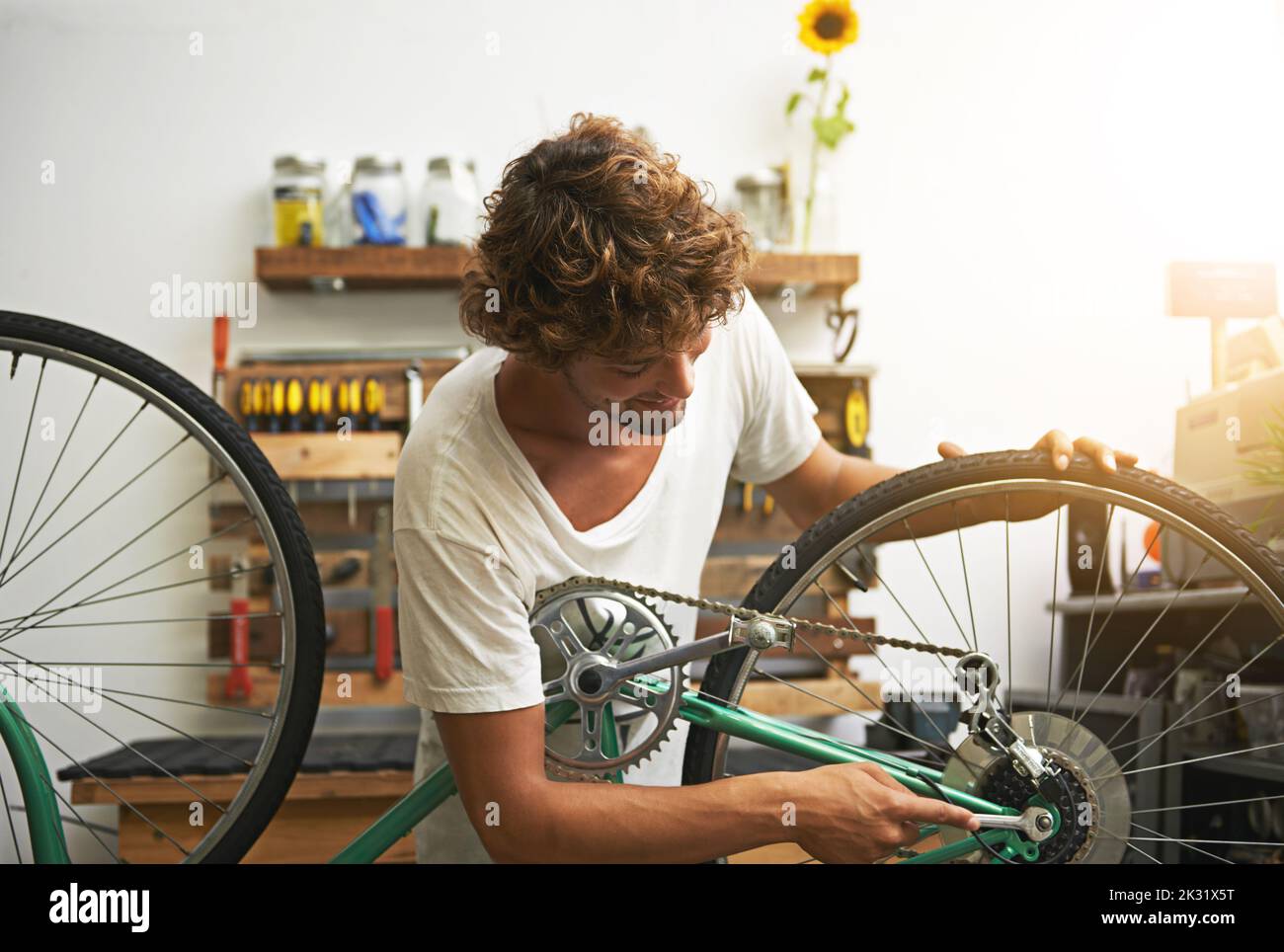 Il connaît son chemin autour d'une bicyclette. Un jeune réparateur de vélo dans un atelier. Banque D'Images