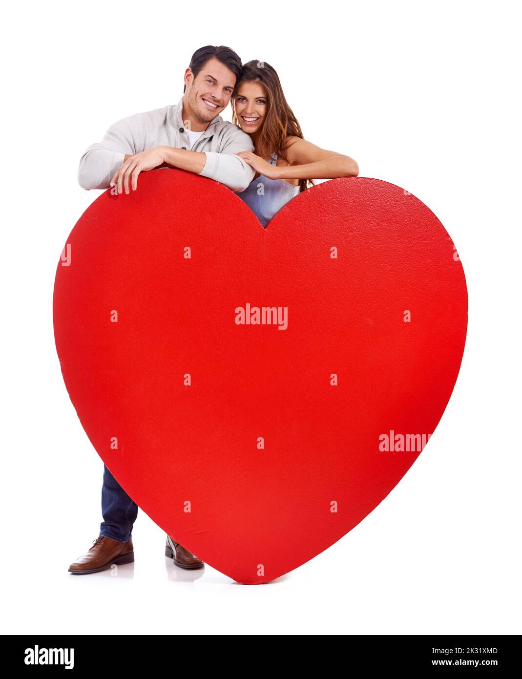 Chaque instant est précieux. Photo de studio d'un couple aimant debout derrière un grand coeur isolé sur blanc. Banque D'Images