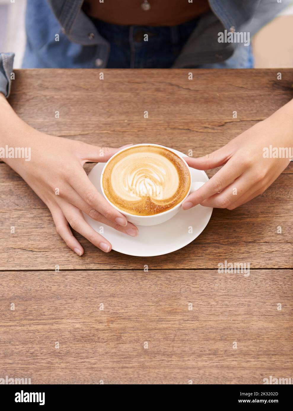 Détendez-vous avec une tasse de café frais. Une jeune femme boit du café dans un café. Banque D'Images