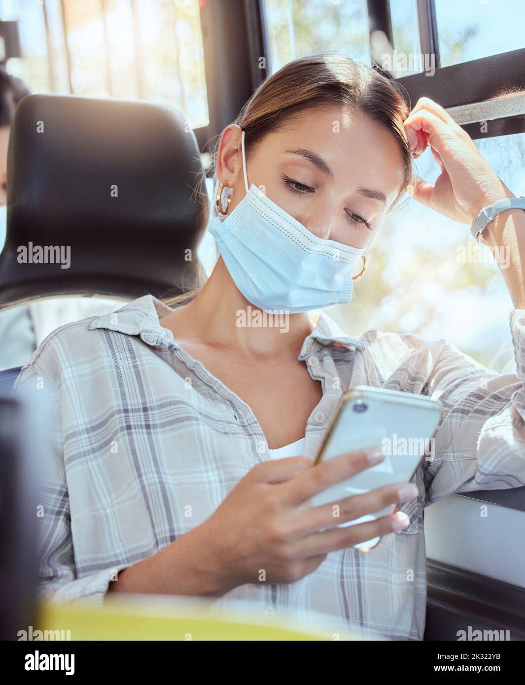 Masque de visage Covid, le transport et la femme avec smartphone lisant les nouvelles en ligne dans le bus et lumière du soleil de la lentille de lumière. Voyager avec un téléphone portable sur un chat mobile Banque D'Images