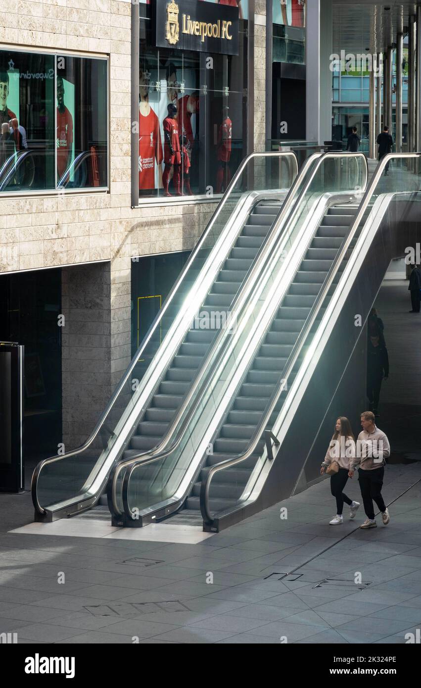 Un jeune couple s'approche des escaliers mécaniques dans le centre commercial Liverpool ONE Banque D'Images