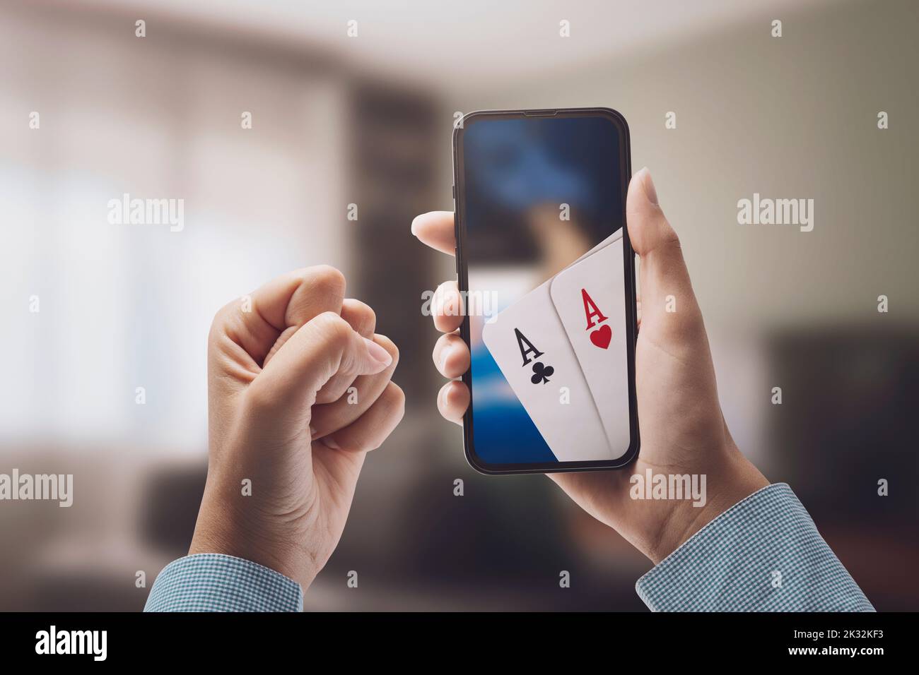 Femme jouant au poker en ligne sur son smartphone à la maison, elle gagne, concept de jeux en ligne Banque D'Images