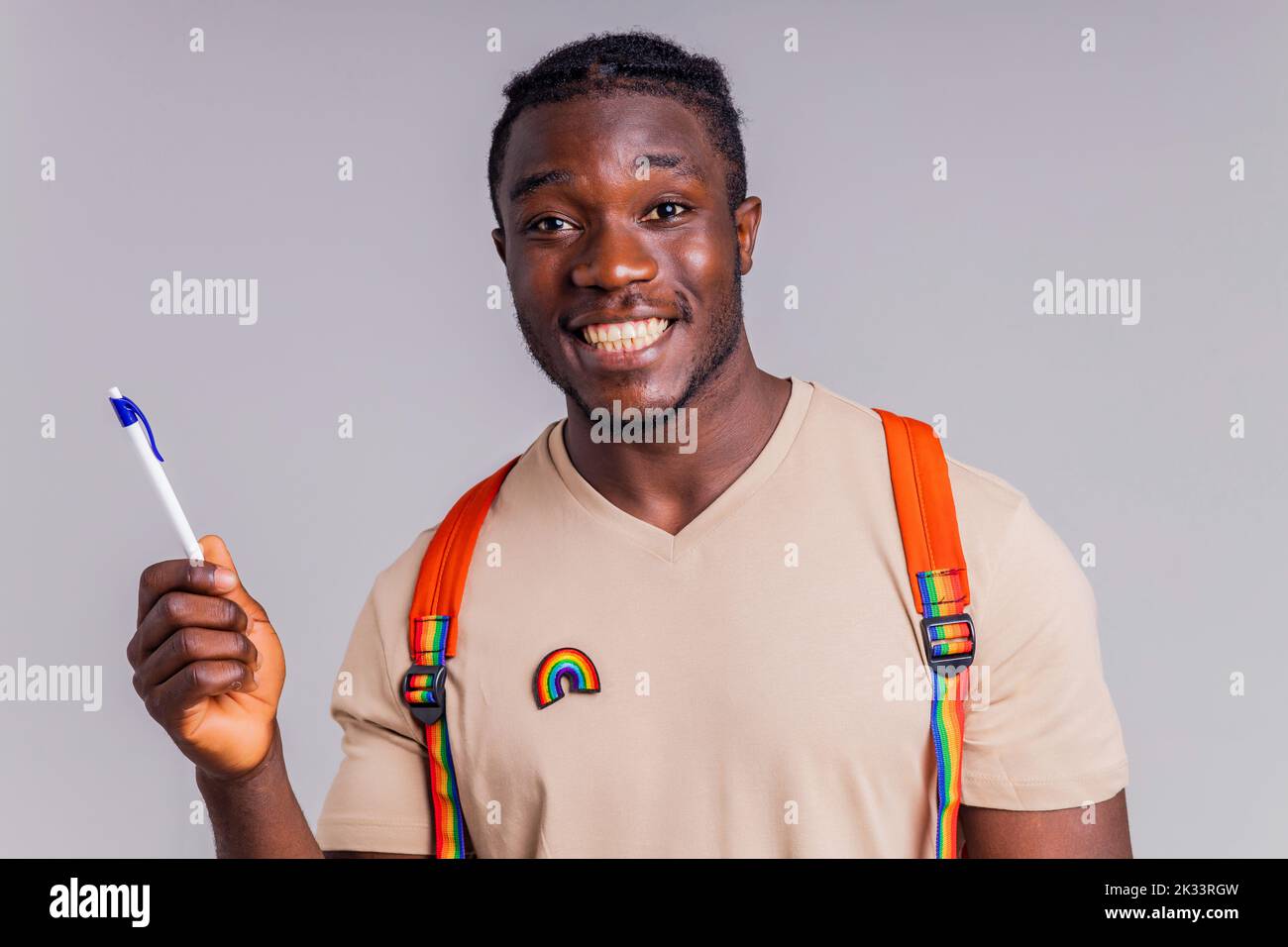 étudiant hispanique avec badge arc-en-ciel sur le t-shirt en studio isolat Banque D'Images