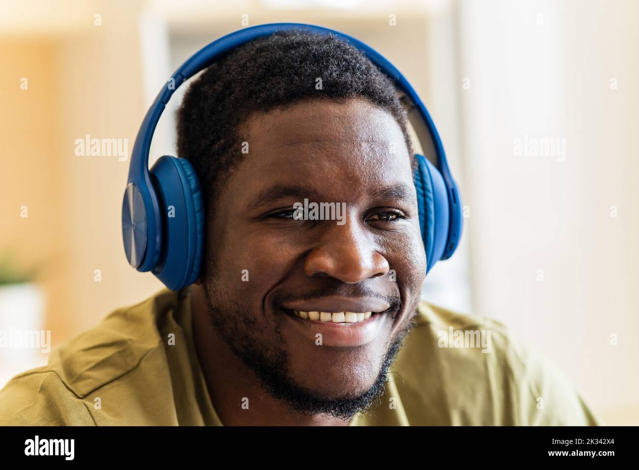 homme hispanique écoutant de la musique dans un casque sans fil à la maison Banque D'Images