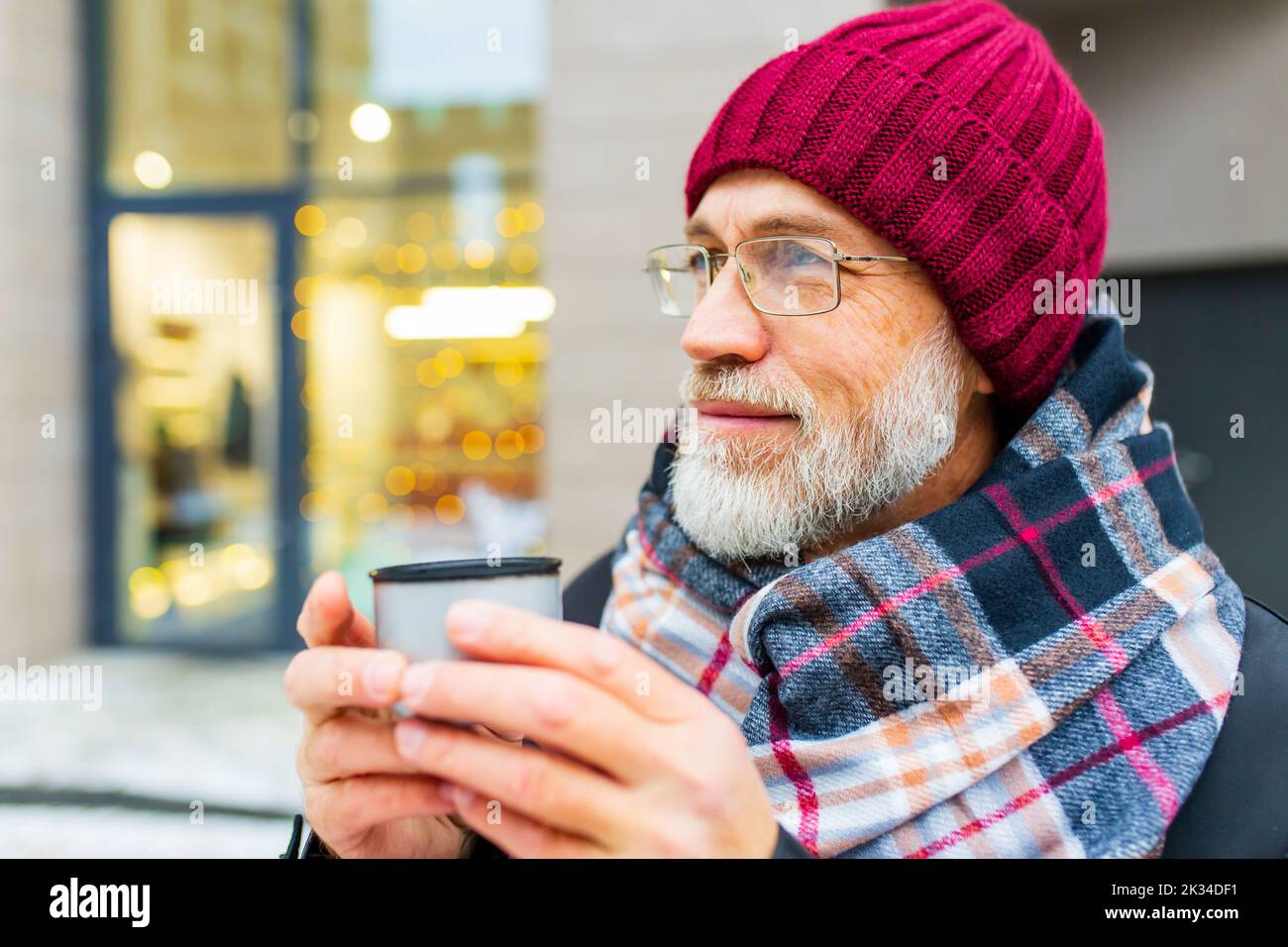 heureux homme mature en hiver marché de noël en plein air avec paysage urbain en arrière-plan Banque D'Images