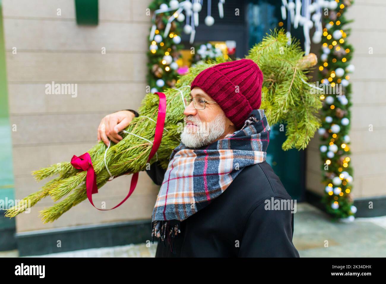 heureux homme mature en hiver marché de noël en plein air avec paysage urbain en arrière-plan Banque D'Images