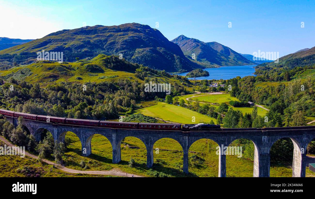 Royaume-Uni, Écosse, Glenfinnan Viaduct avec train à vapeur passant. Viaduc Harry Potter et poudlard expriment des voitures de style. Banque D'Images