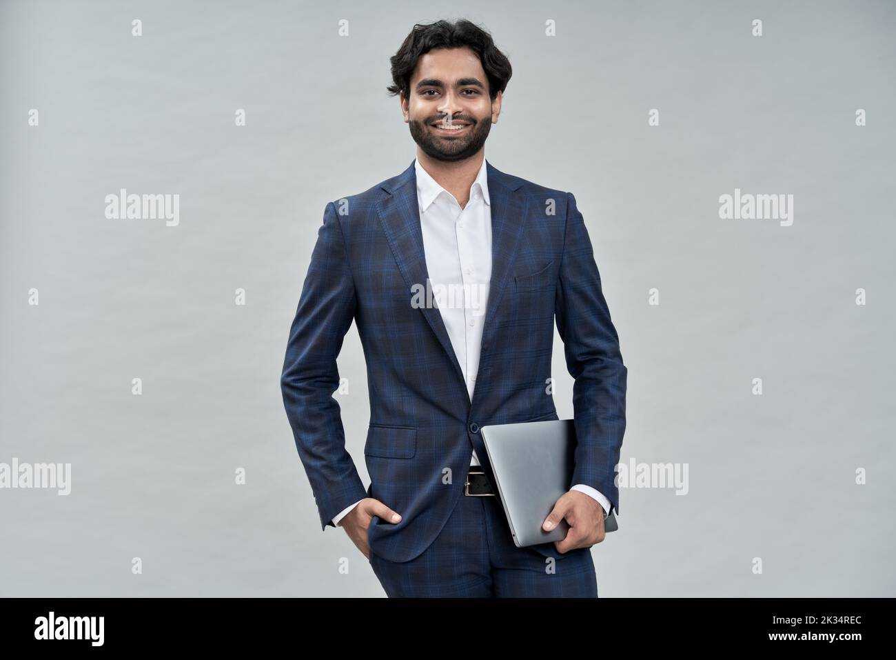 Jeune homme d'affaires arabe indien souriant portant un costume isolé sur beige, portrait. Banque D'Images