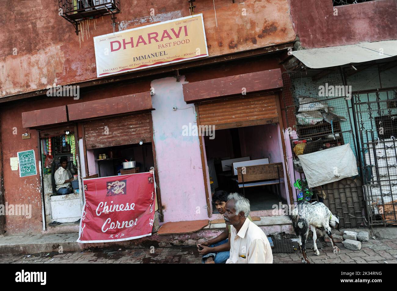 08.12.2011, Mumbai, Maharashtra, Inde, Asie - scène de rue représente les gens assis devant un restaurant de restauration rapide dans le bidonville de Dharavi à Mumbai. Banque D'Images
