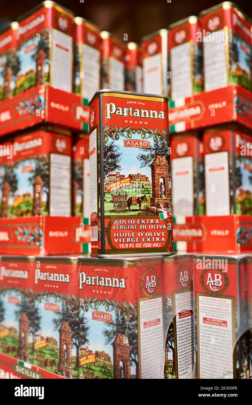 Boîtes d'huile d'olive extra vierge de Partanna empilées sur un marché. En cas de rosaces, plusieurs boîtes sont exposées. Faible profondeur de mise au point. Produit de l'Italie. Banque D'Images