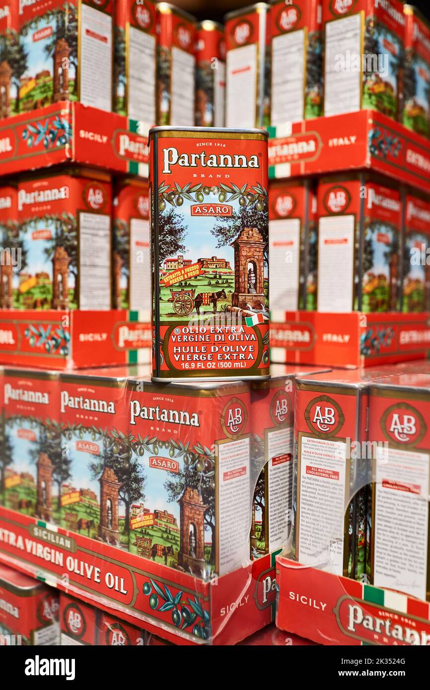 Boîtes d'huile d'olive extra vierge de Partanna empilées sur un marché. En cas de rosaces, plusieurs boîtes sont exposées. Faible profondeur de mise au point. Produit de l'Italie. Banque D'Images