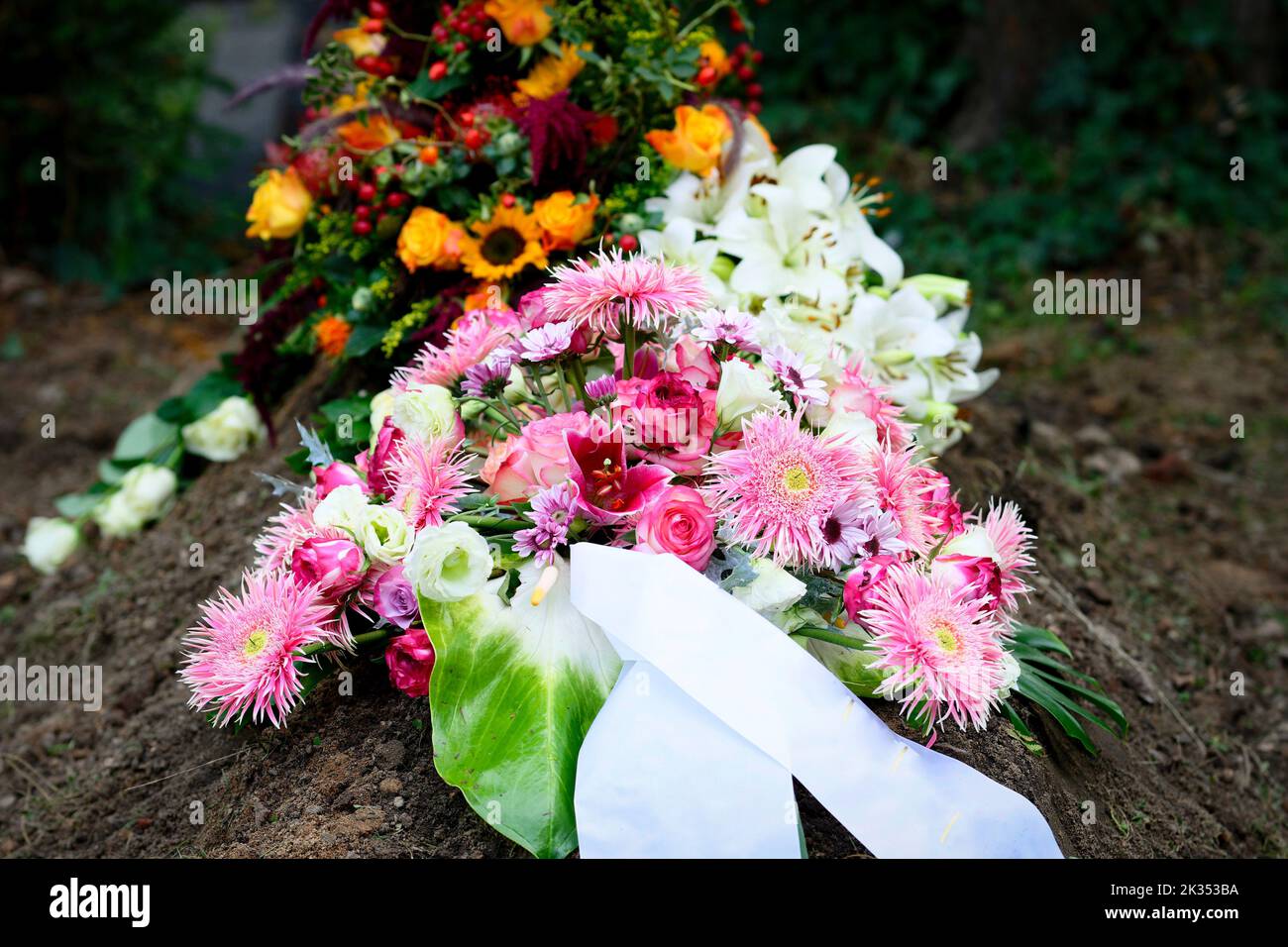 Arrangement coloré de fleurs funéraires sur une tombe après les funérailles Banque D'Images