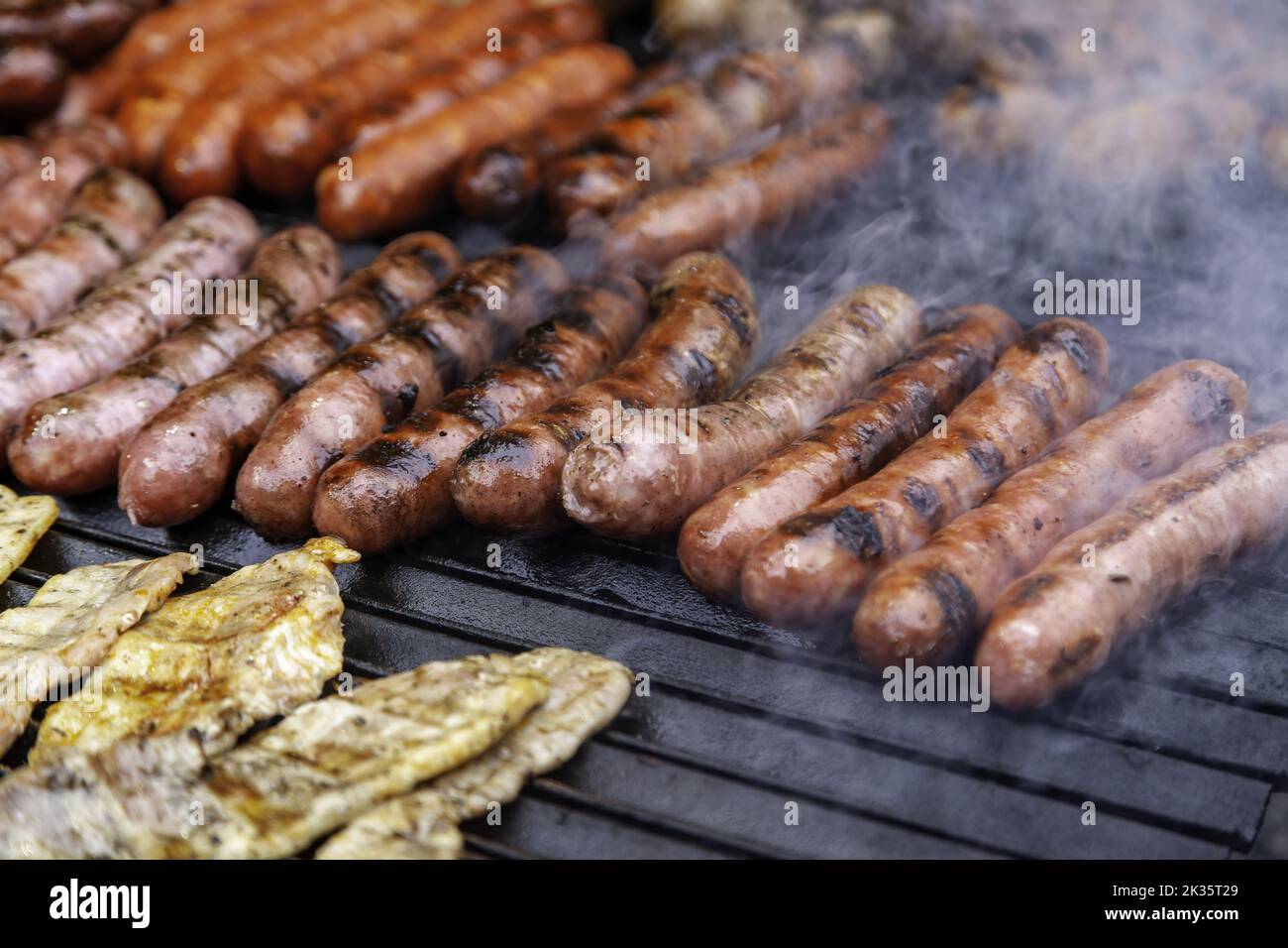 Détail de viande de porc de saucisse cuite au feu sur un barbecue Banque D'Images