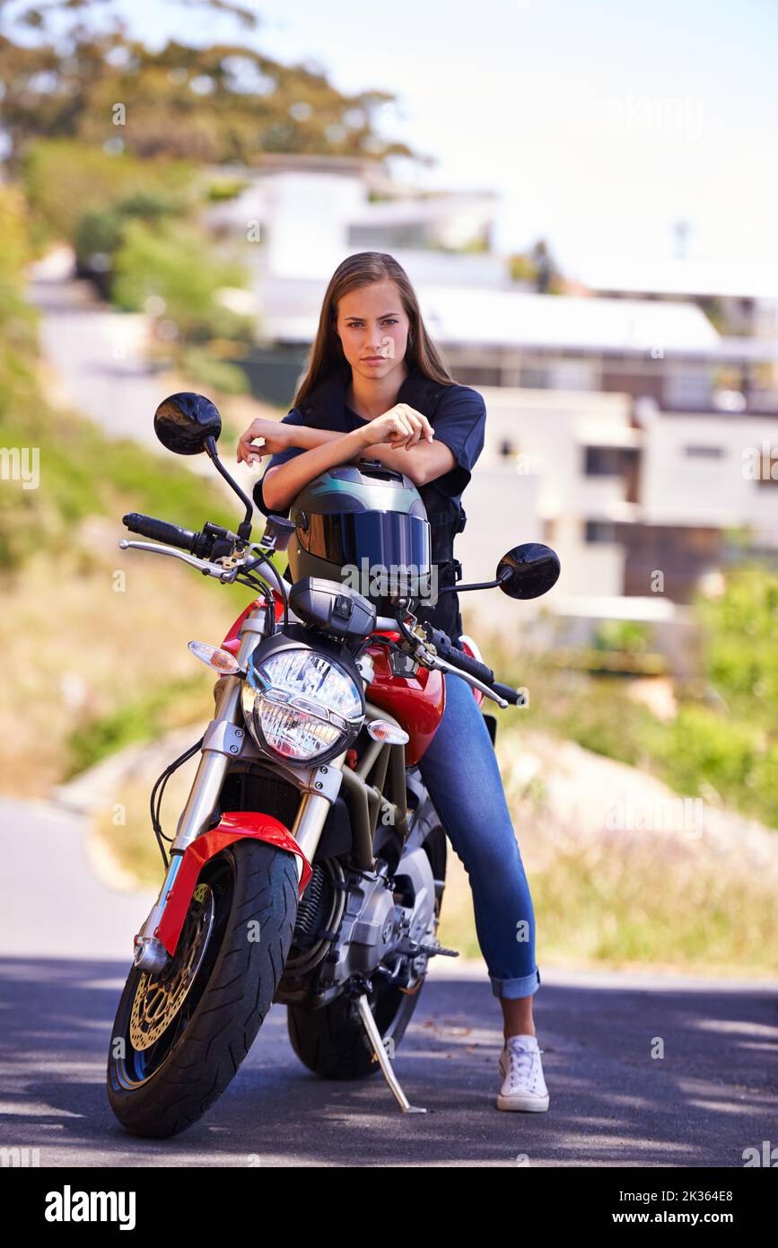 Elle ne répond qu'à elle-même. Une jeune femme attirante assise sur sa moto. Banque D'Images