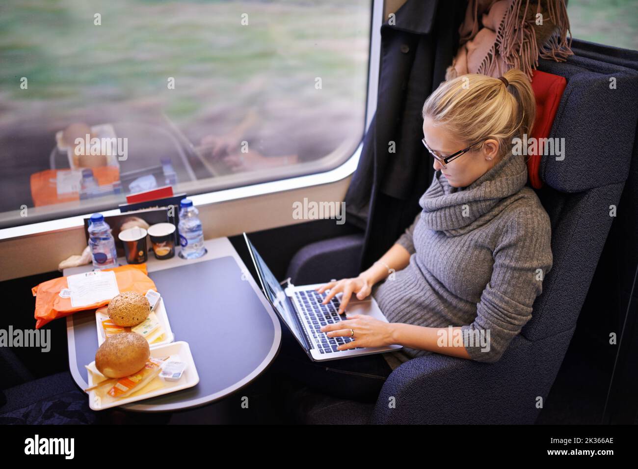 Il est temps de faire du travail. Une jeune femme attrayante voyageant en train. Banque D'Images