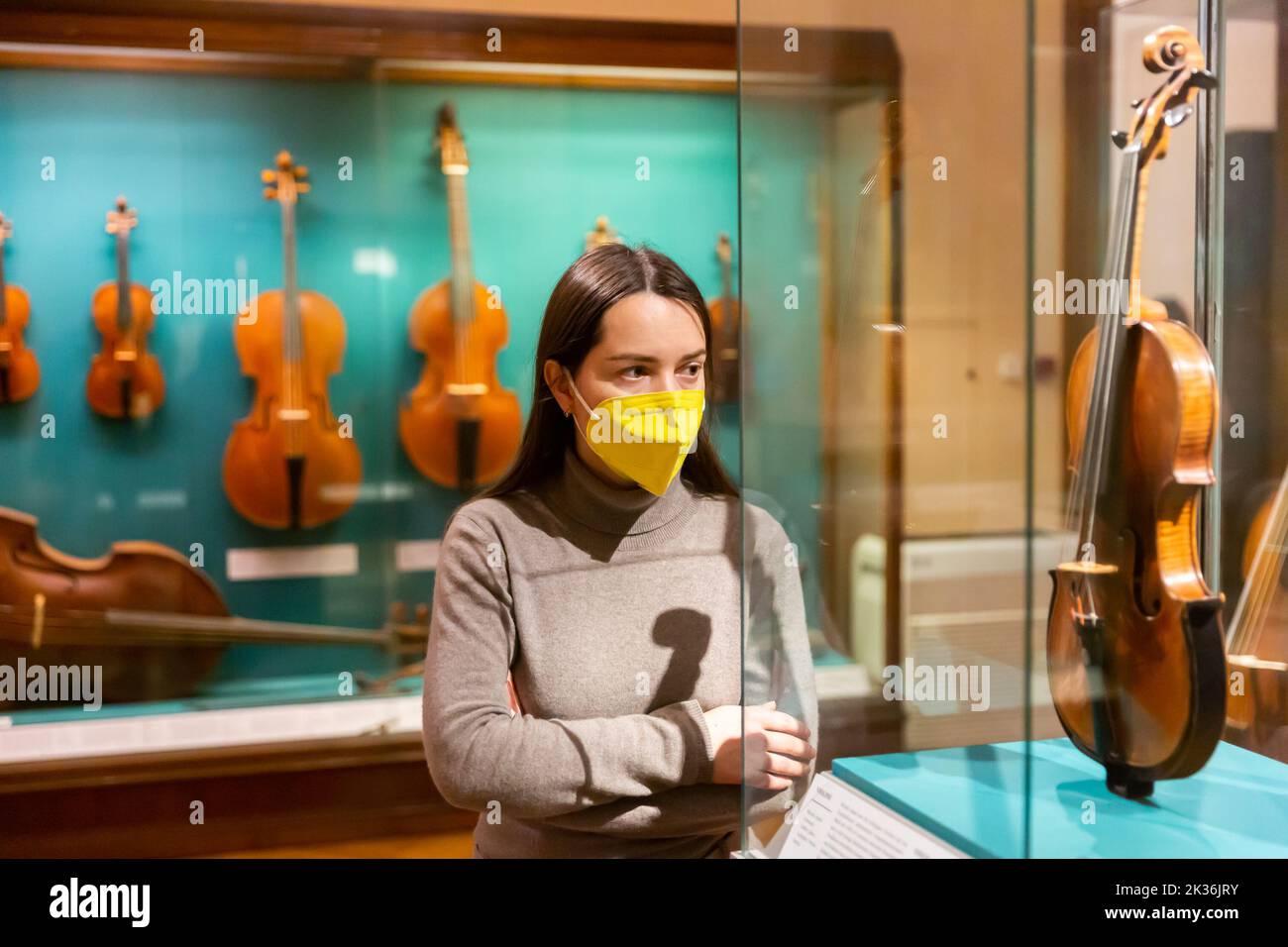 Brunette en masque de protection visite exposition d'instruments de musique médiévaux Banque D'Images