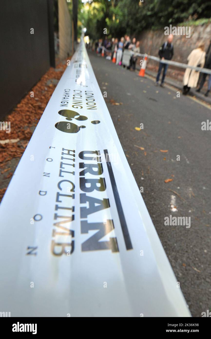 Bande périmétrique au cours de la course de rue Urban Hill Climb organisée par la London Cycling Campaign, parrainée par Osbornes Law. L'événement est une course à plat dans la rue la plus raide de Londres et, en plus des catégories d'âge et de sexe, des compétitions pour les vélos pliants et cargo. Swain’s Lane est l’ascension la plus célèbre et la plus célèbre de Londres. La voie est une section de route extrêmement raide, située entre Hampstead Heath et Highgate Cemetery avec un gradient qui est en moyenne de 9% sur 0,6km, mais augmente à 14% près du sommet de l'ascension. Banque D'Images