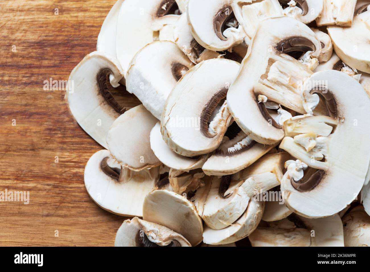 Émincé de champignons sur une planche à découper prête à cuire Banque D'Images