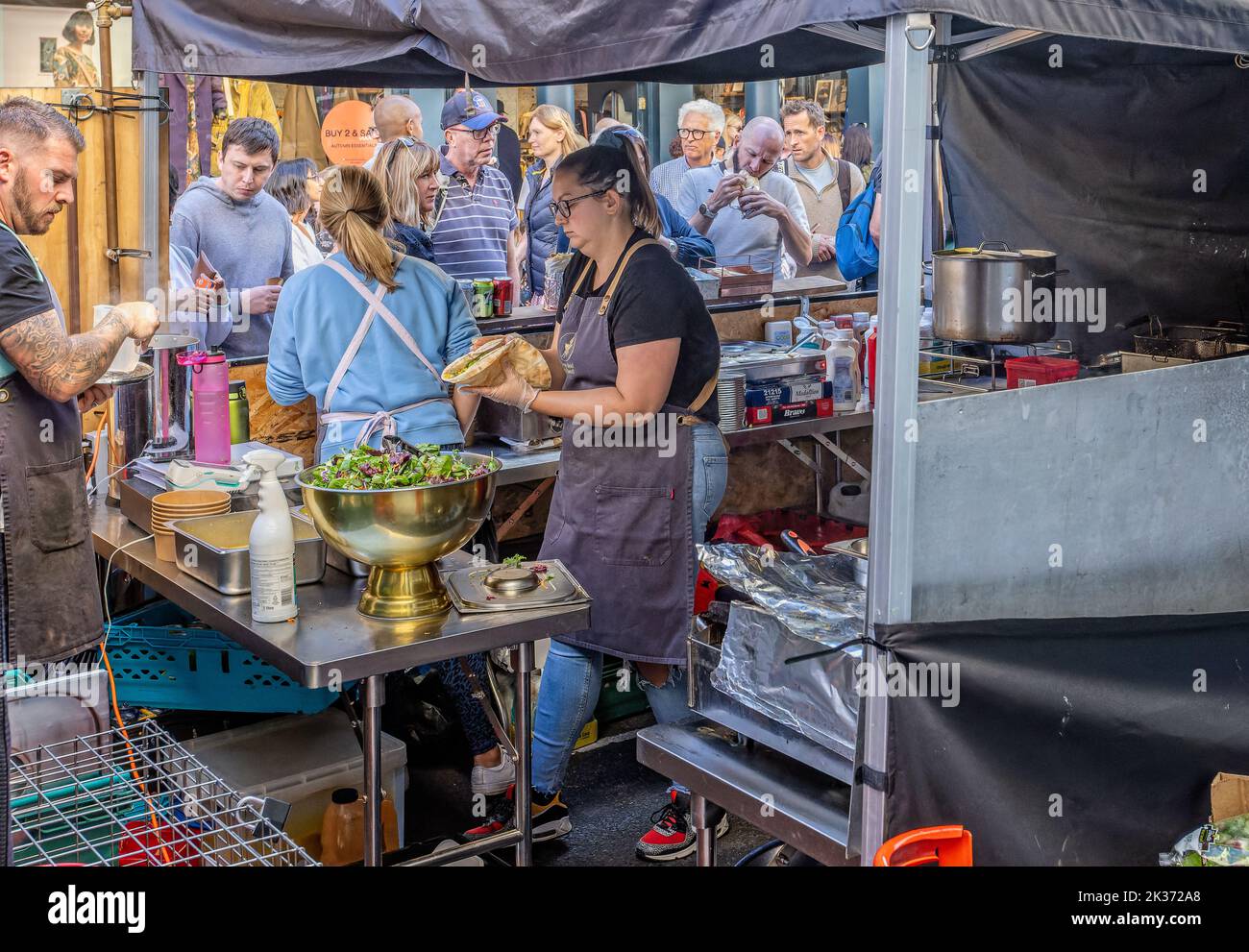 Cuisiniers préparant et servant la nourriture d'un stand au festival de la nourriture de rue Great Bath Feast à Milsom Street, Bath, Avon, Royaume-Uni, le 24 septembre 2022 Banque D'Images