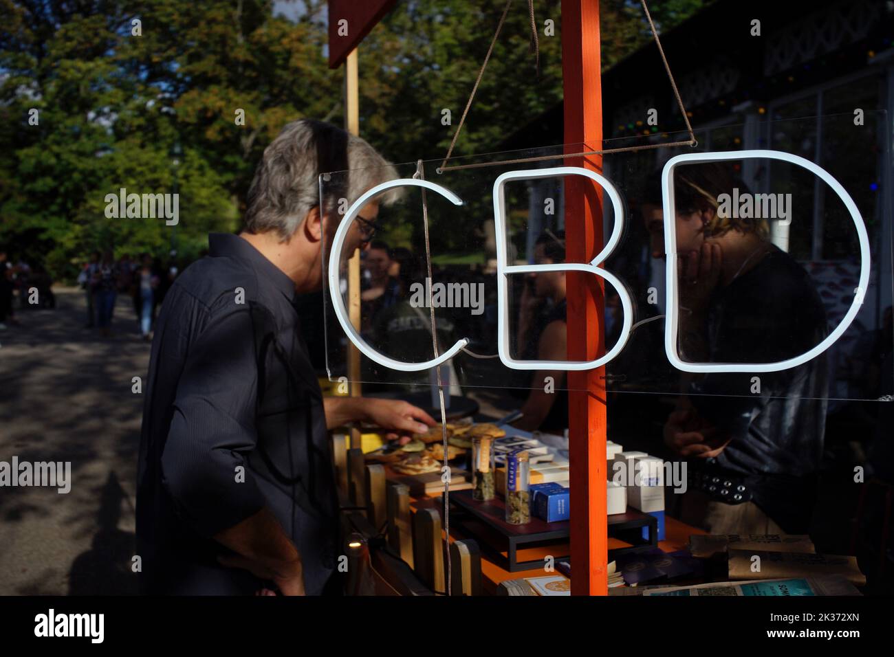 Panneau CBD lumineux sur un stand vendant une gamme de produits CBD (cannididiol) à l'extérieur du café Rosa bonheur, dans le parc des Buttes Chaumont de Paris, Paris, France Banque D'Images