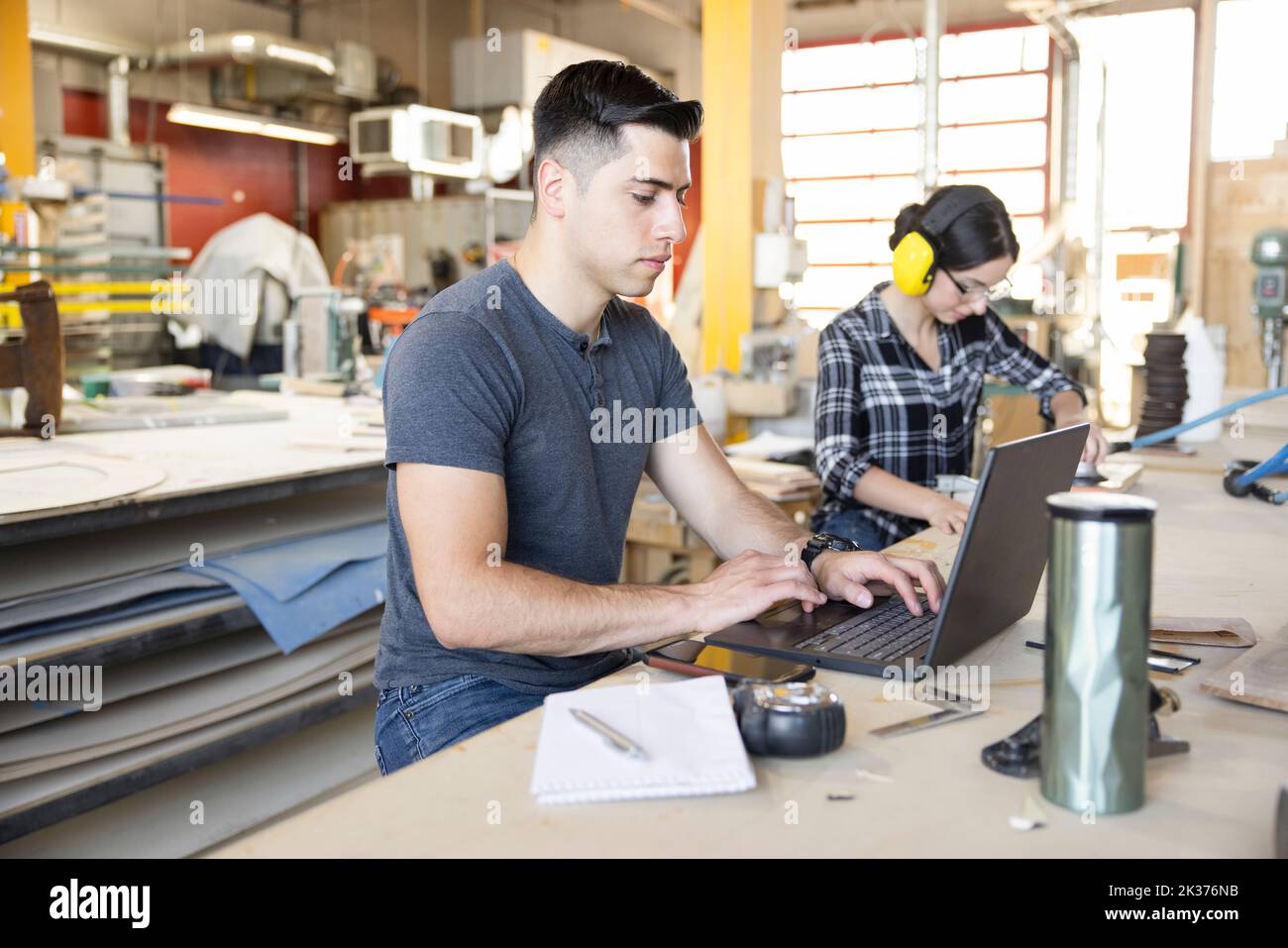 Travailleur du bois utilisant un ordinateur portable dans l'atelier Banque D'Images