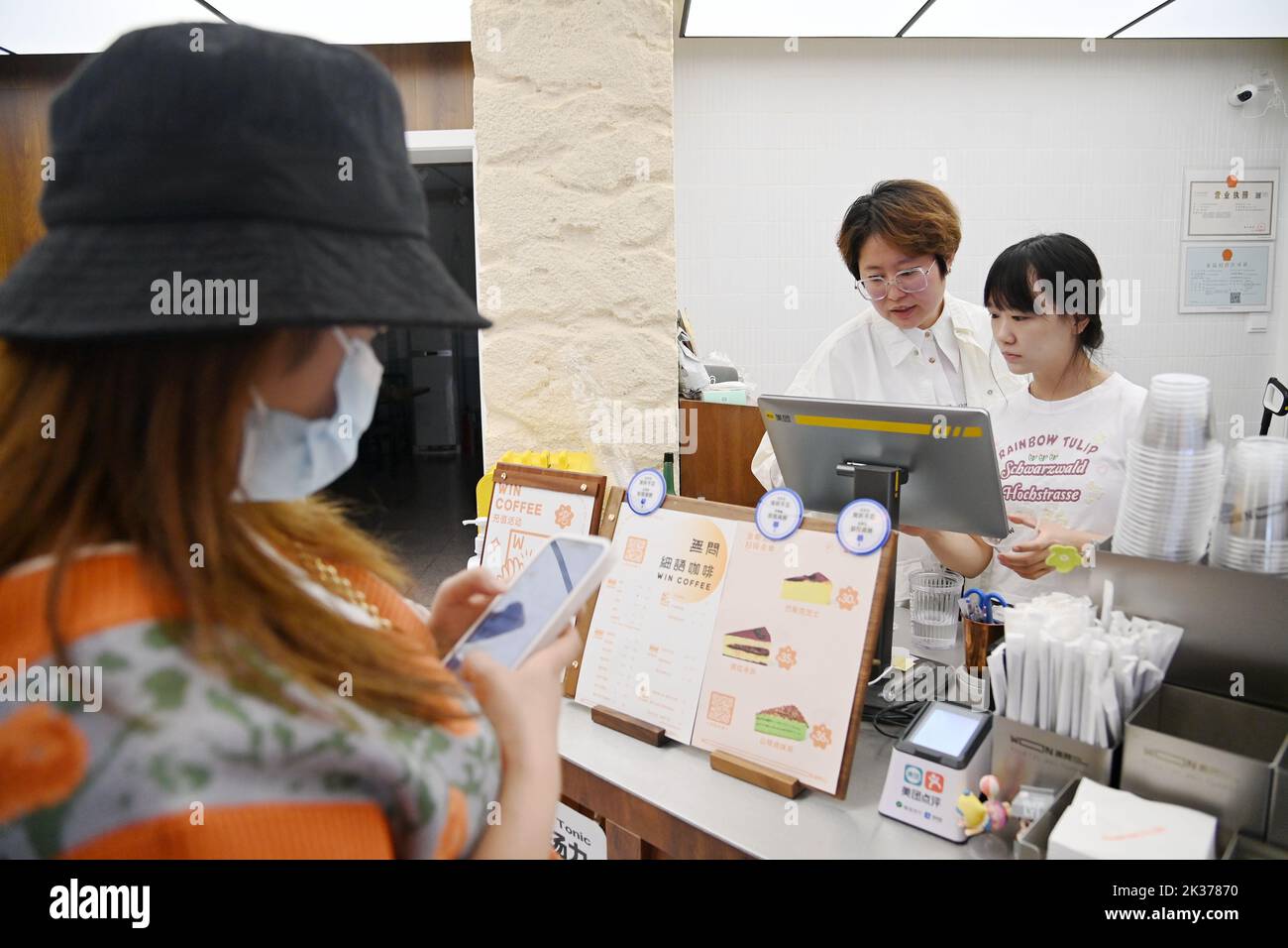 (220925) -- XI'AN, 25 septembre 2022 (Xinhua) -- Chen Jiayue (C), un barista malentendant, travaille dans son propre café de Xi'an, capitale de la province de Shaanxi, dans le nord-ouest de la Chine, le 24 septembre 2022. La Journée internationale des Sourds tombe le quatrième dimanche de septembre. Depuis 2019, Shaanxi Urban Economy School offre une formation gratuite au barista pour les malentendants. Les stagiaires peuvent apprendre à fabriquer du café ainsi que des connaissances sur l'exploitation des cafés au cours du programme de formation, ce qui pourrait les aider à ouvrir la voie soit à démarrer leur entreprise de café, soit à s'engager dans cette industrie. Jusqu'à présent, Mo Banque D'Images