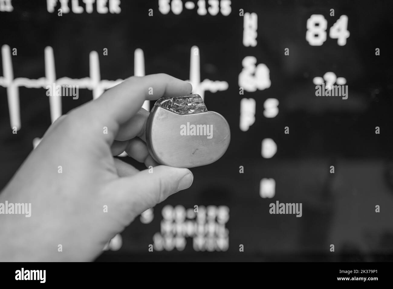 Un défibrillateur implantable est maintenu devant un moniteur ECG Banque D'Images