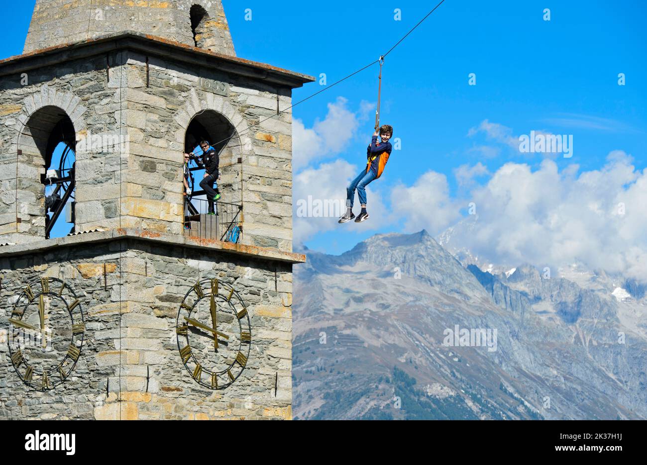 Garçon glissant sur une ligne de fermeture à glissière depuis la tour de l'église, Chinderwältfäscht, Festival mondial des enfants, Heidadorf Visperterminen, Valais, Suisse Banque D'Images