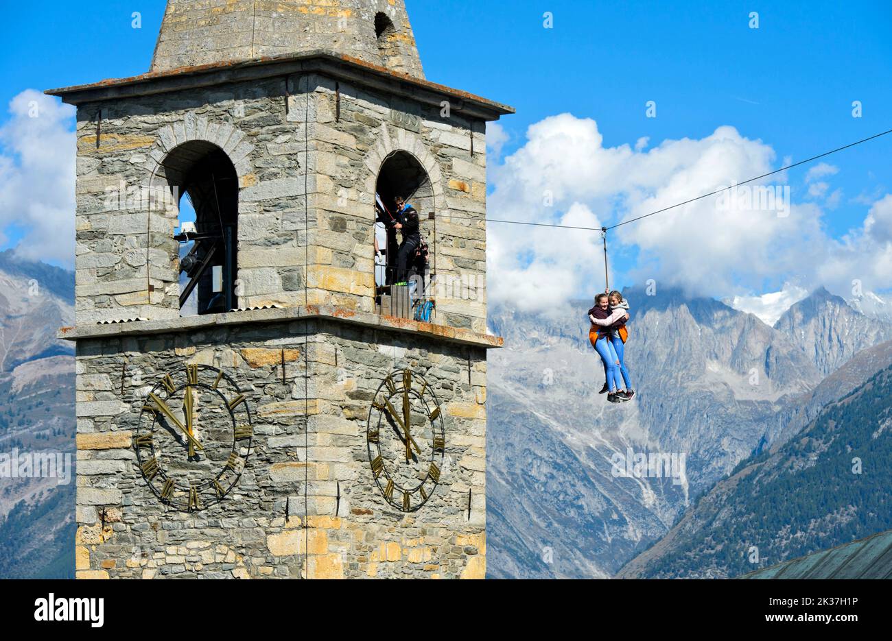 Test de courage, les enfants glissent sur une tyrolienne de la tour de l'église au sol, Visperterminen, Valais, Suisse Banque D'Images