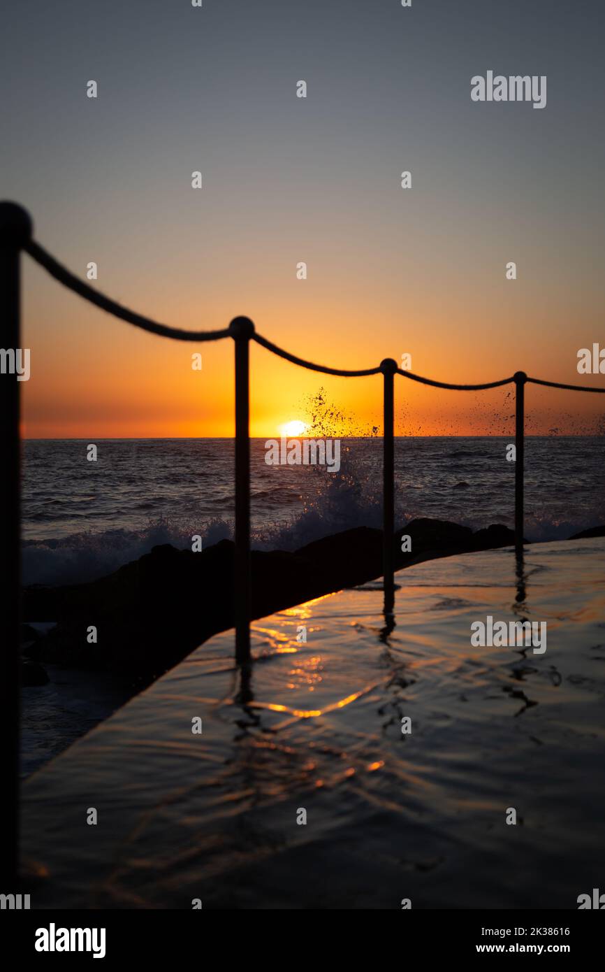 Piscine à côté de l'océan dans les tons chauds du lever du soleil à Sydney, Nouvelle-Galles du Sud, Australie Banque D'Images