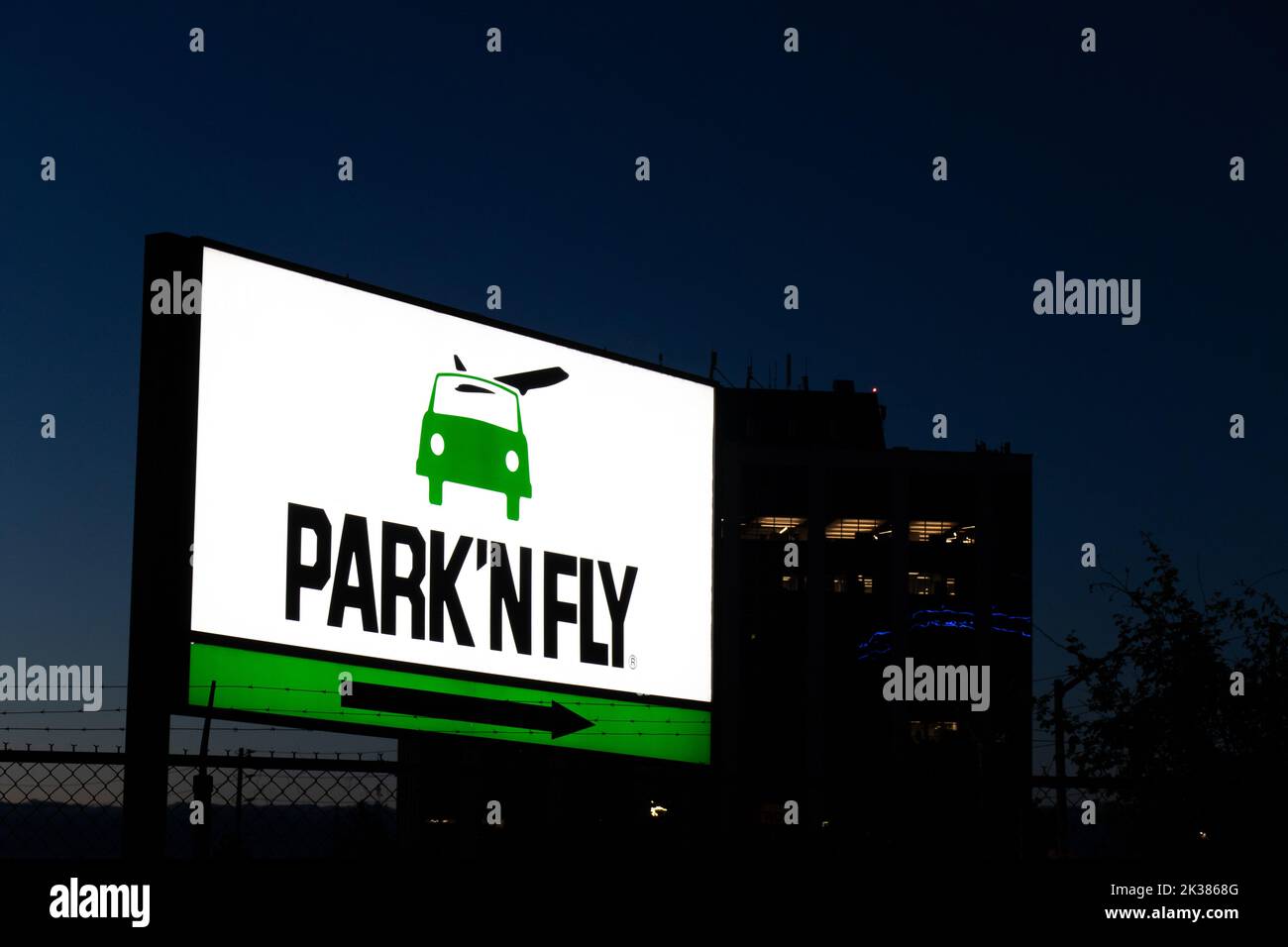 Le logo Park 'N Fly est illuminé sur un panneau près de l'aéroport Pearson de Toronto à l'aube; Park 'N Fly est une compagnie de stationnement populaire hors de l'aéroport. Banque D'Images