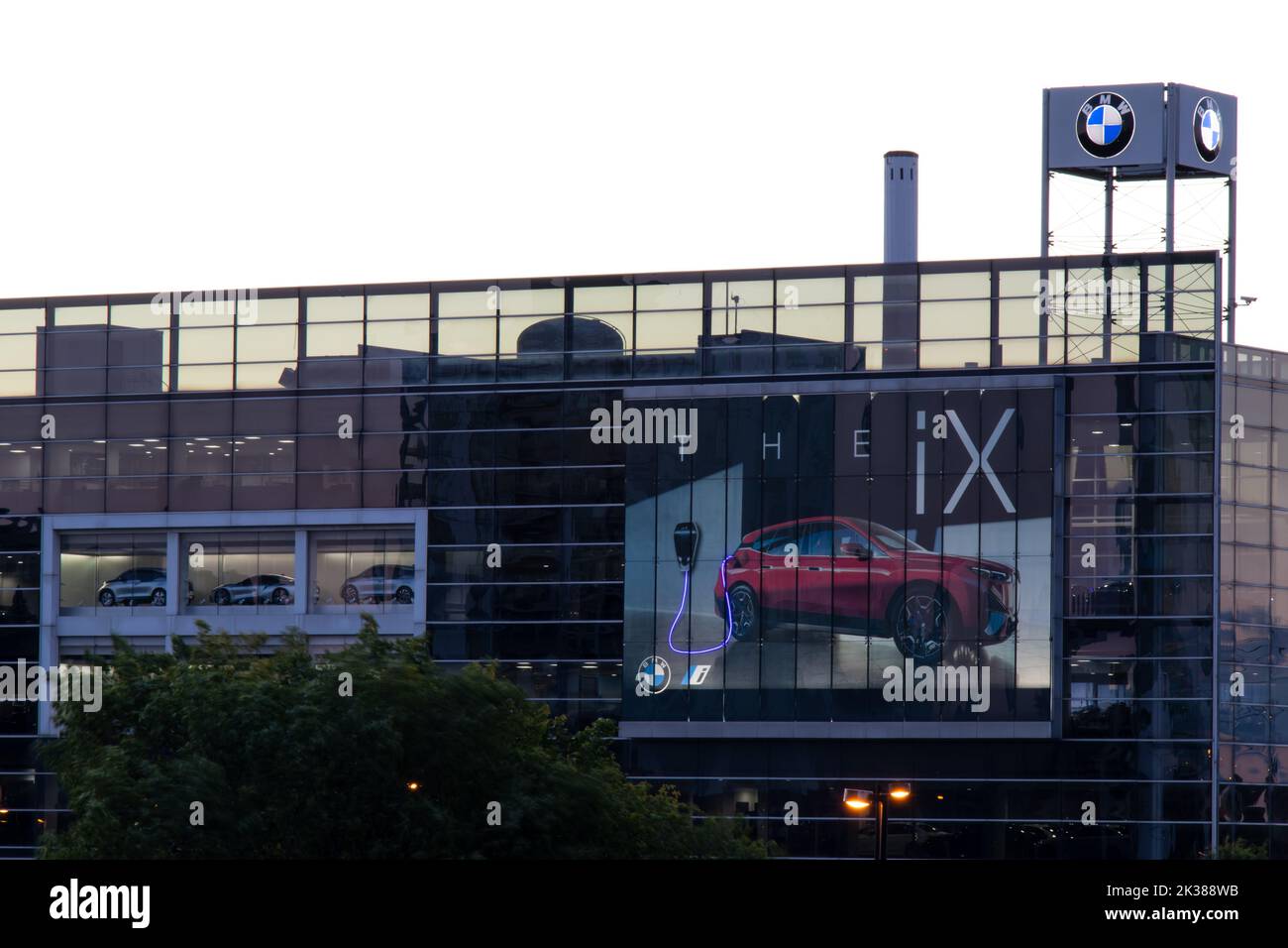 Un grand concessionnaire BMW, avec un panneau d'affichage pour sa nouvelle voiture électrique iX, est vu illuminé à l'aube à Toronto. Banque D'Images