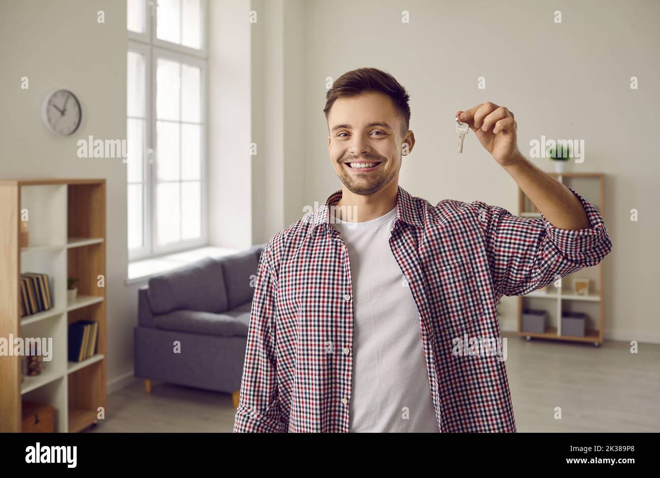Portrait d'un jeune propriétaire heureux souriant et montrant les clés de sa nouvelle maison Banque D'Images