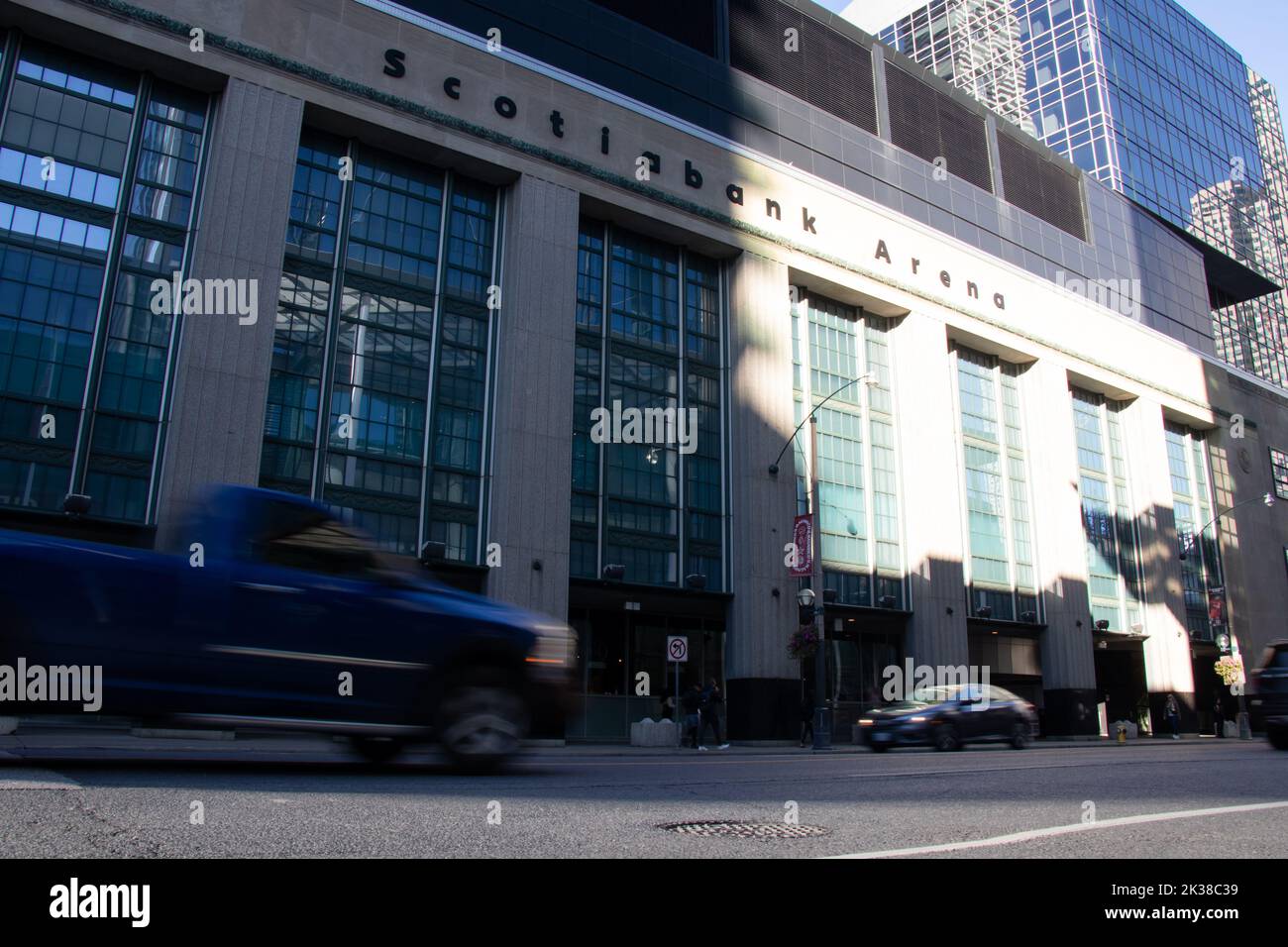 Une aréna ombragée de la Banque Scotia est vue comme la lumière du soleil du matin brille dans le centre-ville de Toronto; la circulation de la rue, floue, passe par. Banque D'Images