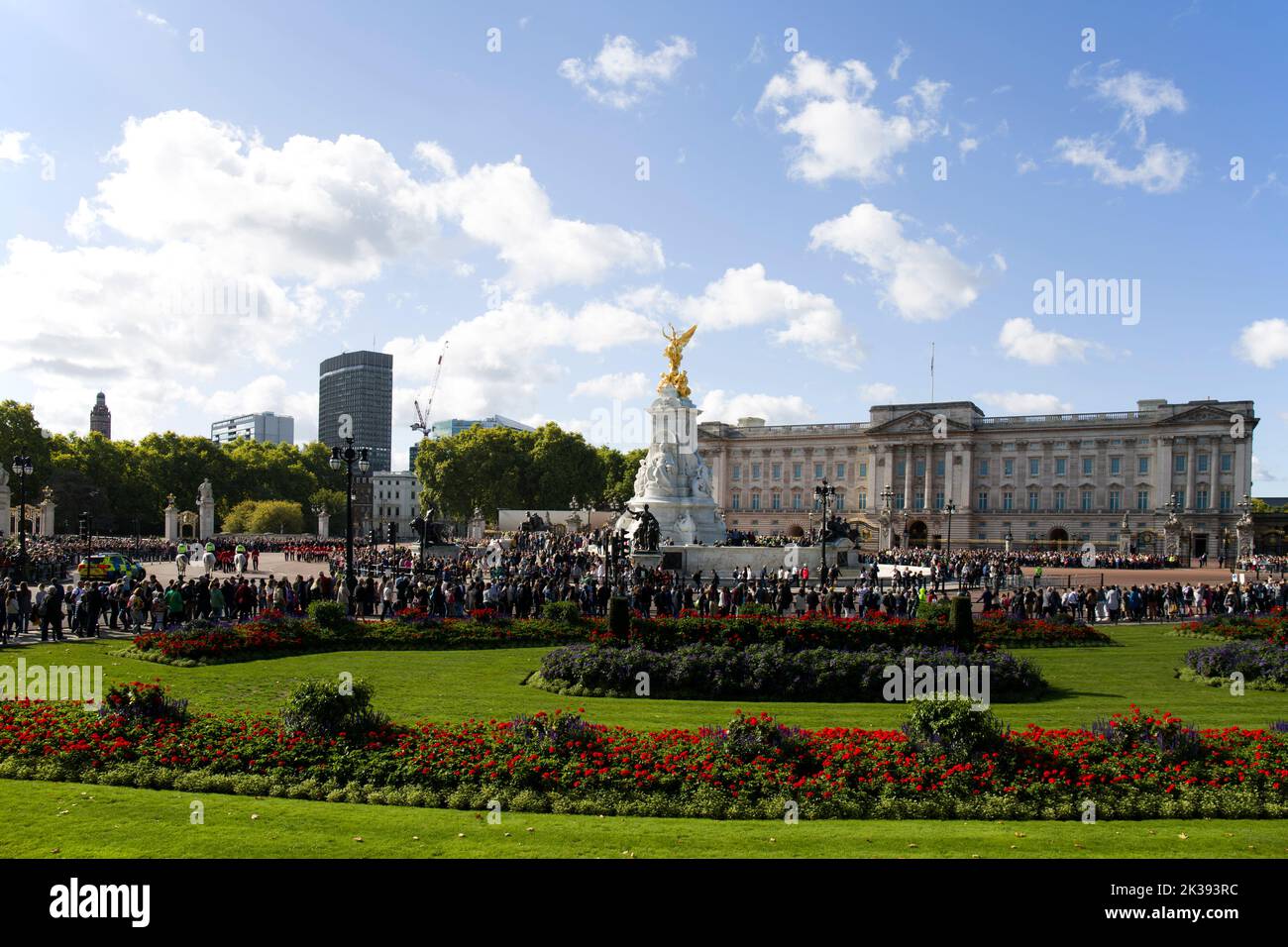 Des foules de touristes et de touristes qui regardent la bande des gardes en marchant Queen Victoria Monument et Buckingham Palace Londres Banque D'Images